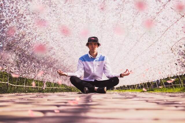 A man sitting on the ground practicing energy healing techniques.