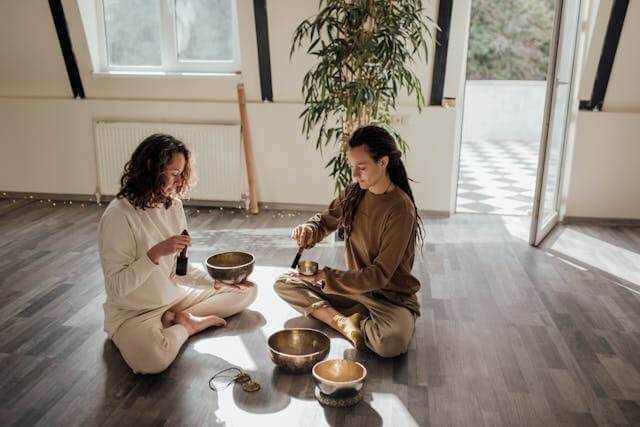 Two woman enjoying a day of visiting healing centers sitting on a floor.