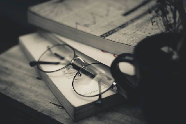 Black and white picture of books and reading glasses to do spiritual readings.