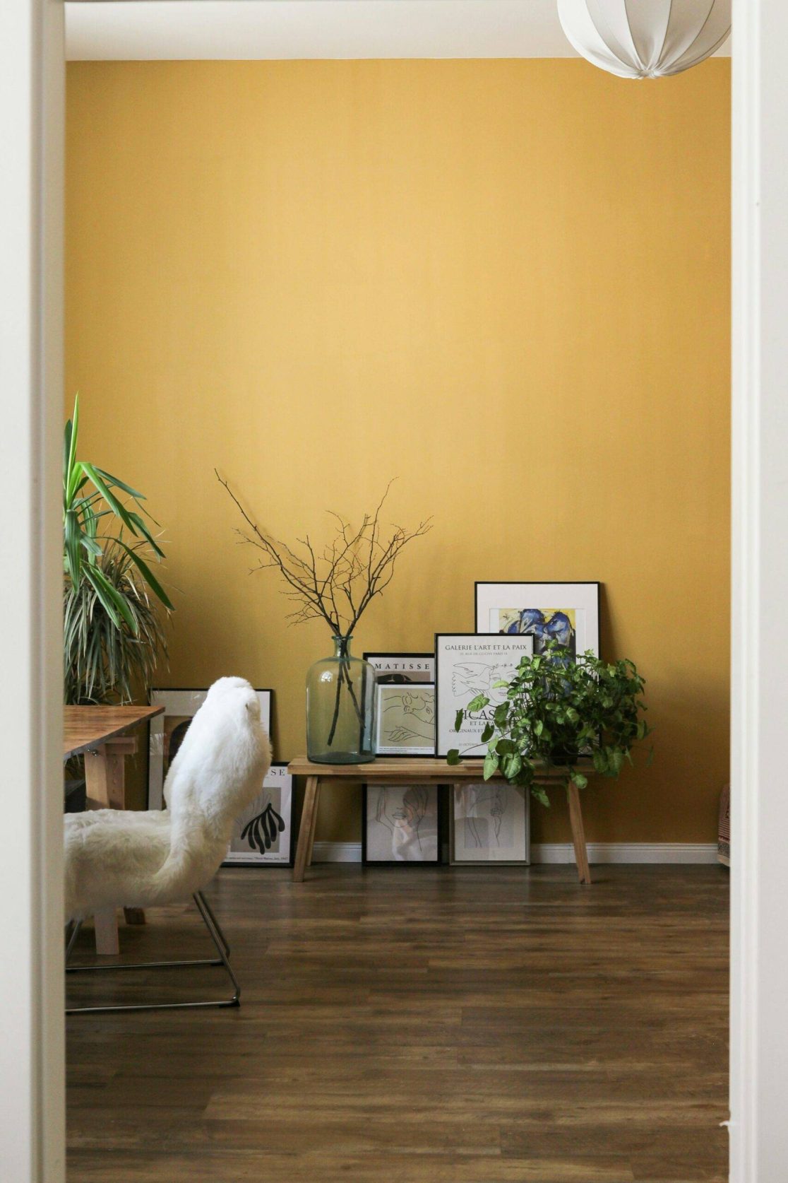 A clean room with a yellow wall giving an example of how to live more mindfully.