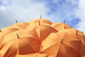 A bunch of open orange umbrellas representing protection against black magic.