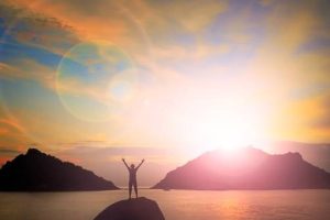 A man standing on a hill overlooking a lake that just had a spiritual cleanse service done.